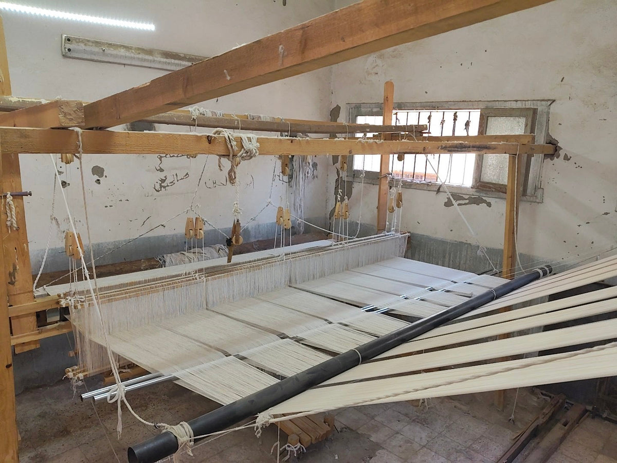 Traditional wooden loom in an Akhmim textile workshop with white warp threads