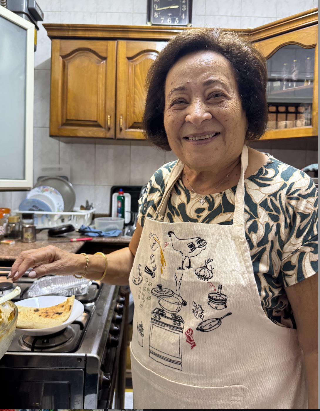 Teta wearing the embroidered Teta Loula apron in her kitchen
