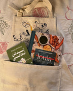 Teta Loula's cookbook and a birthday greeting card tucked into the pocket of a cream Making Molokheya apron